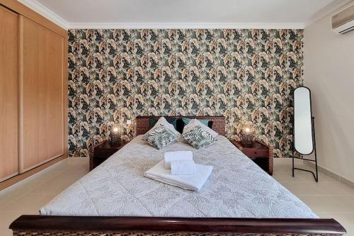 um quarto com uma cama com papel de parede floral em Sea Beside em Albufeira