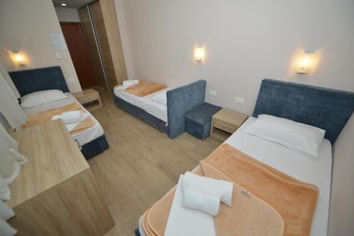 um pequeno quarto de hotel com duas camas e uma cadeira em Hotel Rosabel em Medjugorje