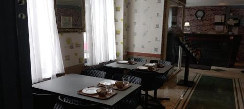 two tables and chairs in a room with windows at Hotel Albergo in Brussels