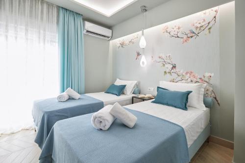 伊拉克里萨Horizon Seaside Living的蓝色和白色的客房内的两张床