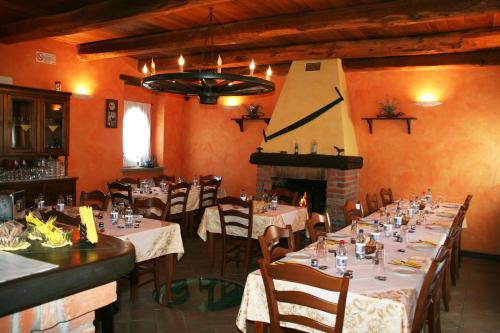 a dining room with tables and chairs and a fireplace at Agriturismo Cascina la Palazzina in Albairate