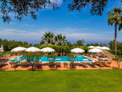 un complexe avec une piscine, des chaises et des parasols dans l'établissement Enticing Villa in Ricadi with Shared Swimming Pool, à Ricadi