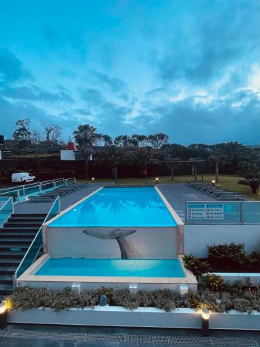 a swimming pool at night with the lights on at Whalesbay Hotel Apartamentos in Capelas