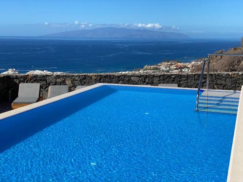 a blue swimming pool with a view of the ocean at Luxury Villa Maria private heated pool Free Car except Christmas in Adeje