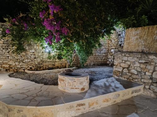 a stone wall with a fountain in a yard at Mainotti's house in Areopoli