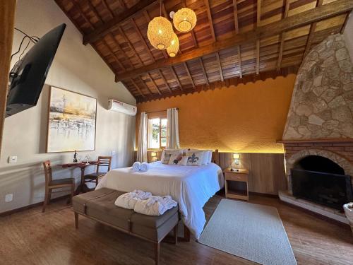 a bedroom with a bed and a fireplace at Pousada Jardim Monte Verde in Monte Verde