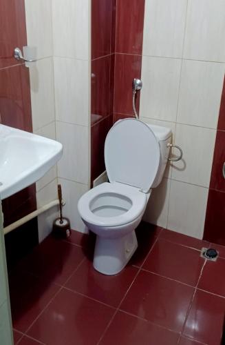 ein Badezimmer mit einem weißen WC und einem Waschbecken in der Unterkunft КОРОНА 