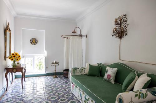 a living room with a green couch and a table at Villa De Cillis Carafa in Torre del Greco