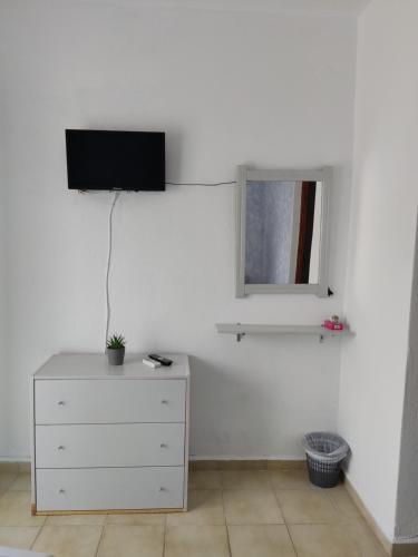 a bedroom with a dresser and a tv on the wall at Eva's Home in Skala Kallirakhis