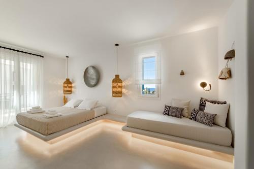 un soggiorno bianco con 2 letti e un divano di Andros Utopia a Mpatsi (Batsi)