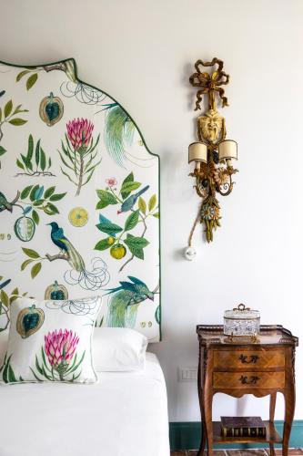 a bed with a floral headboard next to a table at Villa De Cillis Carafa in Torre del Greco