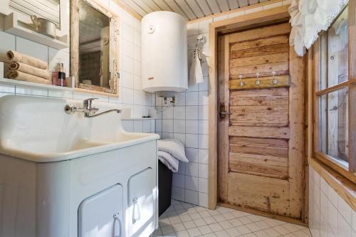 ein Badezimmer mit einem Waschbecken und einer Holztür in der Unterkunft Nurme farm 