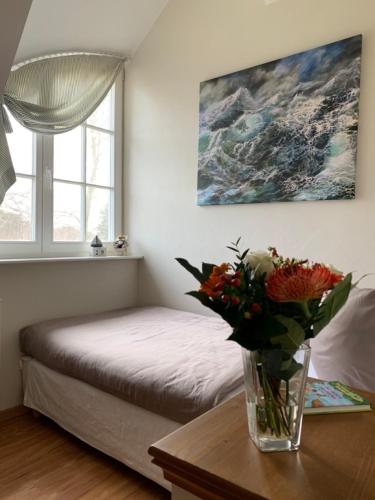 a vase of flowers on a table in a bedroom at Ferienhaus Am Strand in Zingst