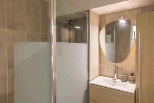 a bathroom with a shower and a sink and a mirror at MYAPPARTBORDEAUX in Bordeaux