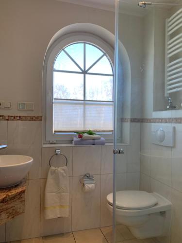 a bathroom with a sink and a toilet and a window at Ferienhaus Am Strand in Zingst