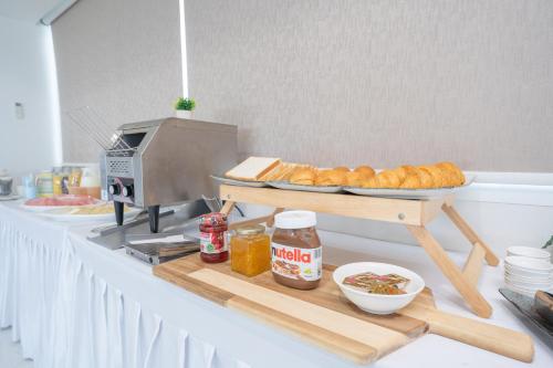 a counter with a plate of croissants and other food at Oriole Residence - Suvarnabhumi Airport in Ban Khlong Thewa