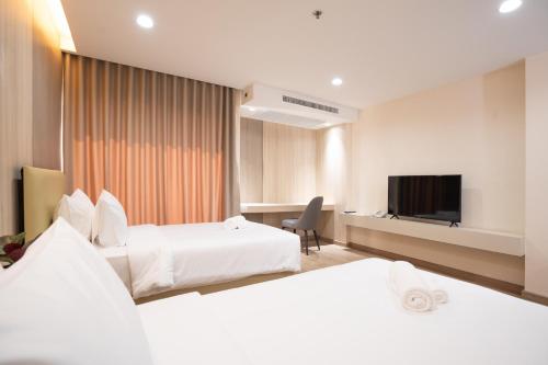 Habitación de hotel con 2 camas y TV de pantalla plana. en Oriole Residence - Suvarnabhumi en Ban Khlong Thewa