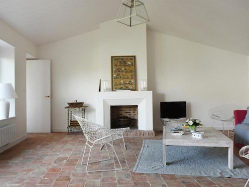 un salon avec une table et une cheminée dans l'établissement Maison au Charme du Village avec Jardin et Wi-Fi - 2 Chambres, 2 Salles d'eau, Cheminée - FR-1-434-11, aux Portes