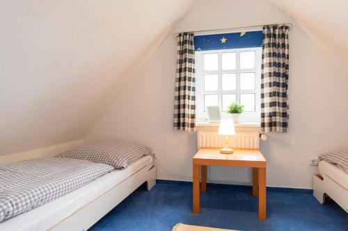 2 camas individuales en una habitación con ventana en Ferienhaus Canvas Canvas Carolinensiel FeWo "Wangerooge", en Wittmund