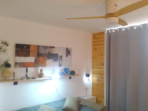 a living room with a couch and a ceiling fan at Loft PLAYA -60m- & TRABAJO -online- in Almería