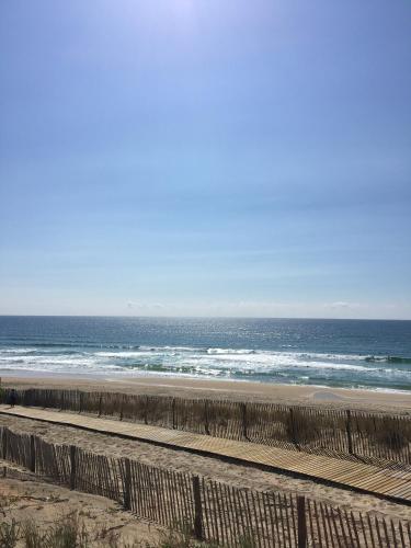 a beach with the ocean and a wooden fence at 2 pièces face océan, Lacanau in Lacanau