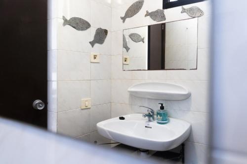 a bathroom with a sink and a mirror at Piso Dunas Blu - Carpe Mundi in Corralejo