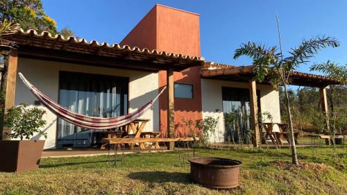 a house with a hammock in front of it at CHALÉS VALE DO LAGO in Capitólio