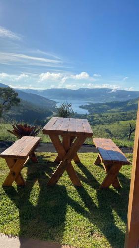 two picnic tables sitting on top of a hill at CHALÉS VALE DO LAGO in Capitólio