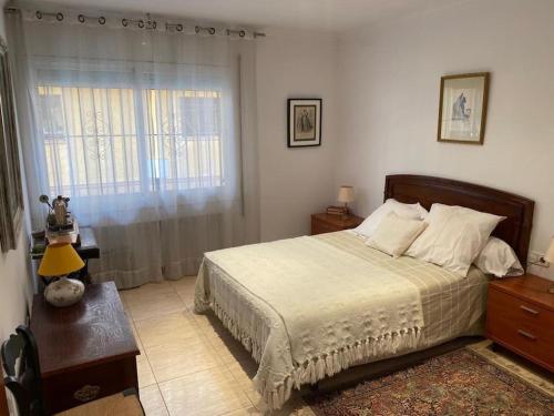 um quarto com uma cama, uma mesa e uma janela em Big & cozy beach canet de Mar em Canet de Mar