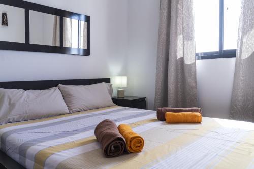 a bedroom with a bed with two towels on it at Piso Dunas Blu - Carpe Mundi in Corralejo