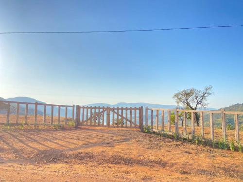 a wooden fence in the middle of a dirt road at CHALÉS VALE DO LAGO in Capitólio