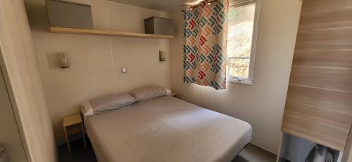 アレニス・デ・マルにあるEl Carlitosのベッドと窓が備わる小さな客室です。