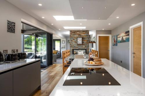 a kitchen and living room with a table and a fireplace at Kingsley Paddocks in Chew Stoke