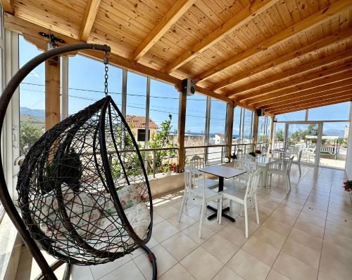 a porch with a swing and a table and chairs at Joni Apartments in Ksamil