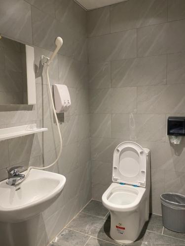 a bathroom with a white toilet and a sink at Kenting Heng-Chung Art Hostel in Hengchun