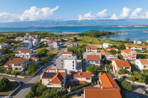 une vue aérienne d'une petite ville à côté d'une masse d'eau dans l'établissement Apartmani Kraljičina plaža, à Nin