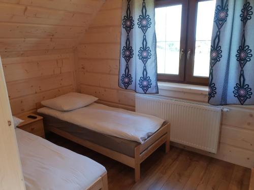 um pequeno quarto com 2 camas e uma janela em Chochołowsko-Witowski Wypoczynek em Witów