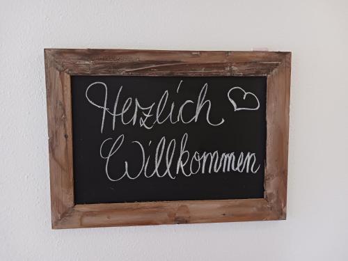een bord met krijtborden dat voor de wilgenmantic op een muur staat bij Lausitzer Auszeit in Laubusch