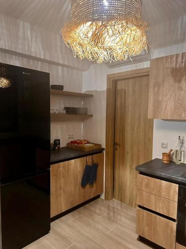 a kitchen with a black refrigerator and a chandelier at The Nine Graces - Kastraki Villas with Private Swimming Pool in Kastraki Naxou