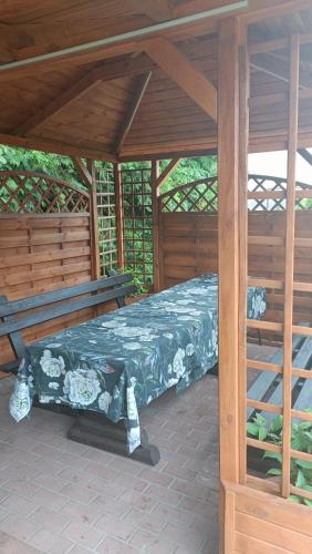 a bed under a wooden structure with a bench at SŁONECZNIK domki letniskowe Charbrowo-Łeba in Charbrowo