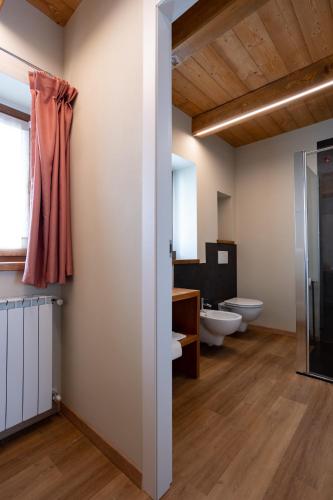 a bathroom with two sinks and two toilets at Bed & Bike La Stalla in Masera