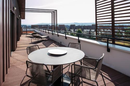 a table and chairs on a balcony with a view at Thalazur Cabourg - Hôtel & Spa in Cabourg