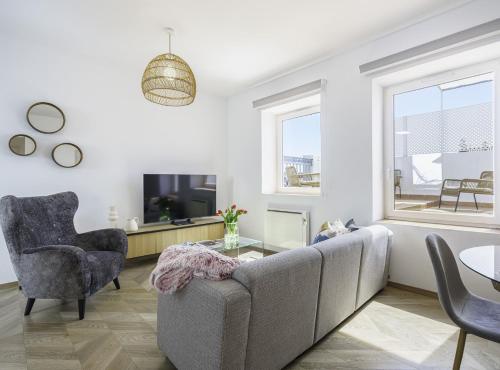 ein Wohnzimmer mit einem Sofa und einem TV in der Unterkunft SibsBcn-Paseo de Gracia Penthouse-Luxury-Terraces in Barcelona