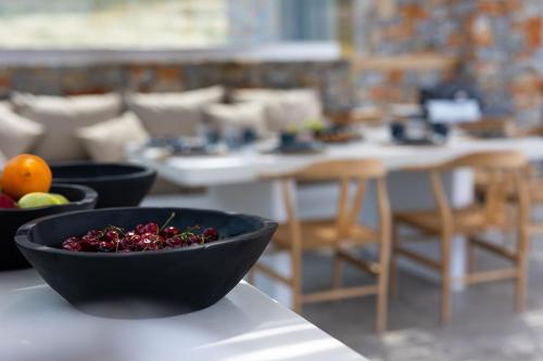 a black bowl of fruit sitting on a table at The Nine Graces - Kastraki Villas with Private Swimming Pool in Kastraki Naxou