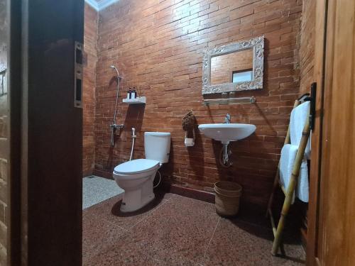 a bathroom with a toilet and a sink at La Tavisa Hotel Borobudur in Magelang