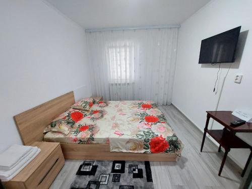 a small bedroom with a bed with flowers on it at Apartament Beatrice in Năvodari
