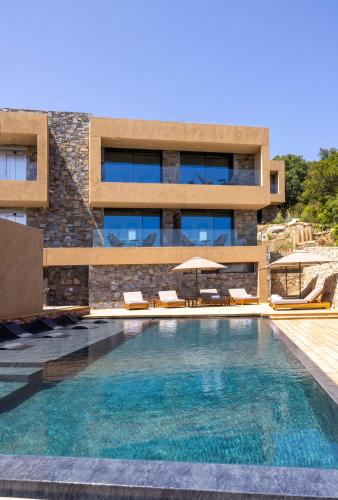 une maison avec piscine devant un immeuble dans l'établissement Les Regalia Hôtel & Spa, à Sainte-Lucie de Porto-Vecchio