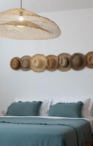 a bedroom with a bed with a chandelier at The Nine Graces - Kastraki Villas with Private Swimming Pool in Kastraki Naxou
