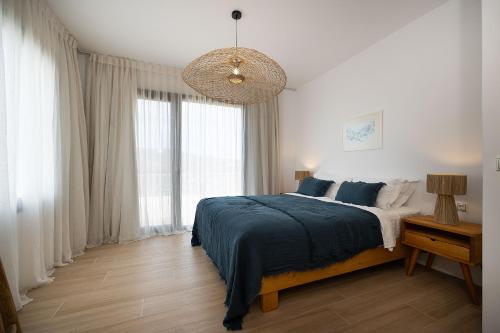 a bedroom with a bed and a large window at The Nine Graces - Kastraki Villas with Private Swimming Pool in Kastraki Naxou