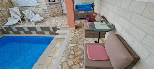 an overhead view of a pool with chairs and a table at Apartments Villa Bella Vista Hvar in Hvar